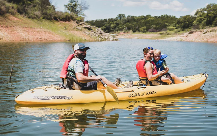Man, women and child on a kayak in a river
